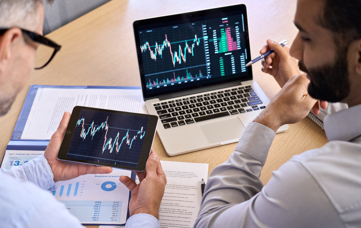 Two Male Brokers Discussing Crypto Trading Charts